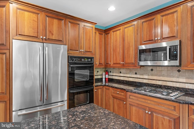 1 Derbyshire Way, Wilmington, DE 19807 - kitchen featuring stainless steel appliances, brown cabinetry, backsplash, dark stone counters, and recessed lighting