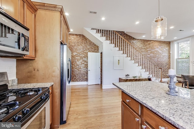 251 8th St NE, Washington, DC 20002 - kitchen with appliances with stainless steel finishes, brick wall, light wood-style floors, recessed lighting, and brown cabinetry