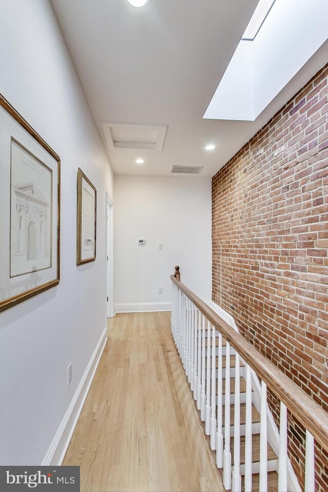 251 8th St NE, Washington, DC 20002 - hall featuring brick wall, light wood-style floors, attic access, and baseboards