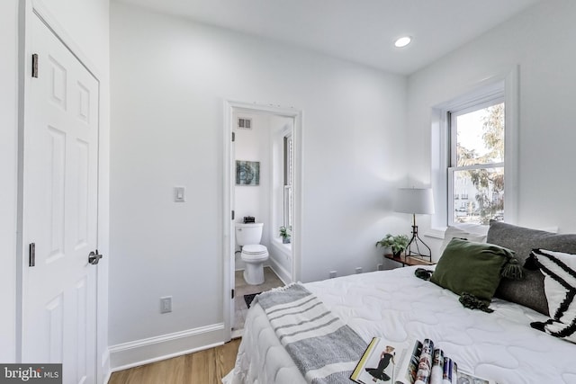 251 8th St NE, Washington, DC 20002 - bedroom with wood finished floors, baseboards, ensuite bathroom, and recessed lighting