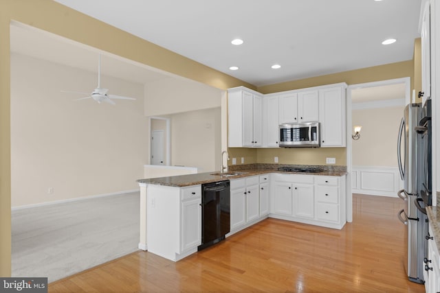 327 Astilbe Dr, Kennett Square, PA 19348 - kitchen featuring black appliances, a sink, dark stone countertops, a peninsula, and white cabinets