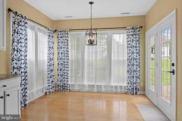 327 Astilbe Dr, Kennett Square, PA 19348 - unfurnished dining area with a chandelier, light wood-style floors, and healthy amount of natural light