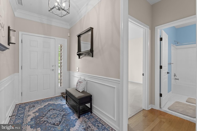 327 Astilbe Dr, Kennett Square, PA 19348 - foyer entrance featuring wood finished floors, a chandelier, ornamental molding, and wainscoting