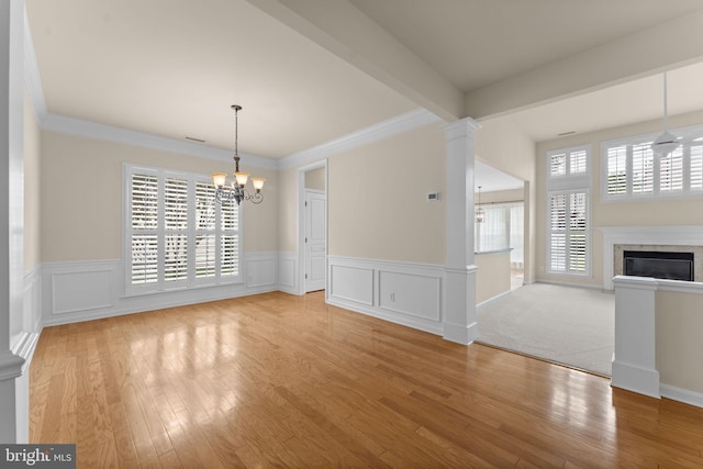 327 Astilbe Dr, Kennett Square, PA 19348 - unfurnished dining area with a chandelier, plenty of natural light, wainscoting, wood finished floors, and crown molding