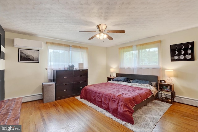 800 Delta Rd, Red Lion, PA 17356 - bedroom with an AC wall unit, a baseboard heating unit, wood finished floors, a textured ceiling, and baseboards
