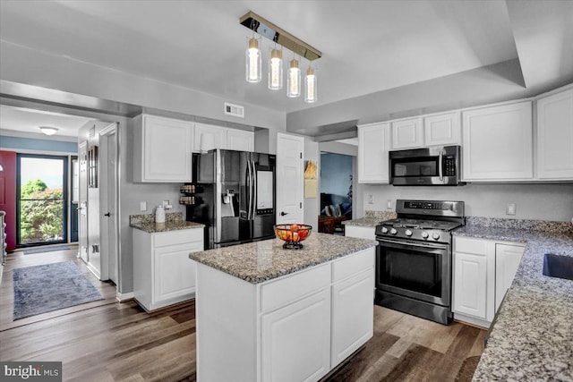 701 Antietam Dr, Douglassville, PA 19518 - kitchen with stainless steel appliances, wood finished floors, a center island, light stone countertops, and white cabinets