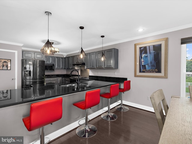 9112 Chesapeake Ave, Sparrows Point, MD 21219 - kitchen featuring stainless steel fridge, black microwave, a sink, dark countertops, and a kitchen bar