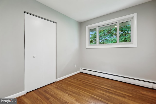 10400 Conover Dr, Silver Spring, MD 20902 - unfurnished bedroom with a baseboard radiator, wood finished floors, a closet, and baseboards