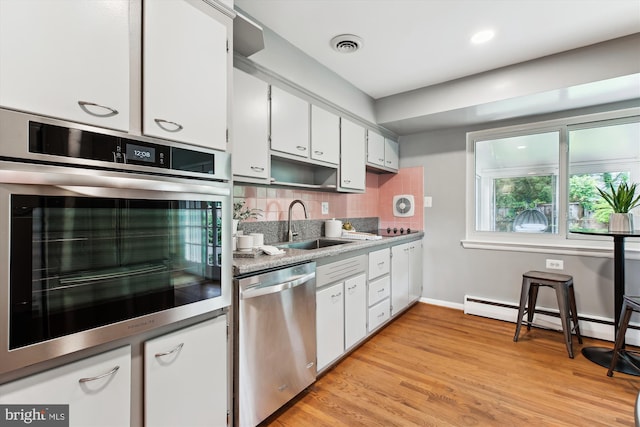 10400 Conover Dr, Silver Spring, MD 20902 - kitchen with stainless steel appliances, a sink, white cabinetry, backsplash, and baseboards