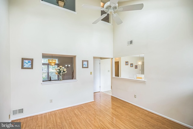 56 Ridgewood Way, Burlington, NJ 08016 - unfurnished living room with wood finished floors, a chandelier, baseboards, a ceiling fan, and a high ceiling