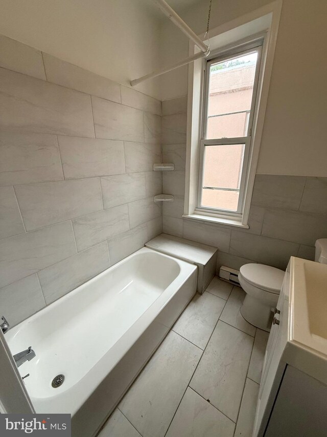 2324 N Lambert St, Philadelphia, PA 19132 - bathroom featuring tile walls, vanity, toilet, bathtub / shower combination, and a baseboard radiator