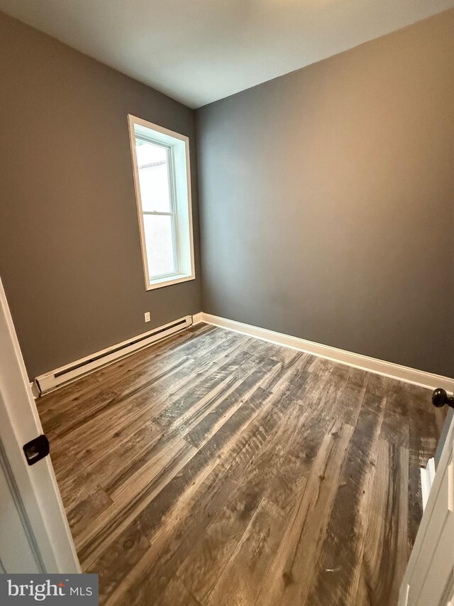 2324 N Lambert St, Philadelphia, PA 19132 - spare room featuring a baseboard heating unit, wood finished floors, and baseboards