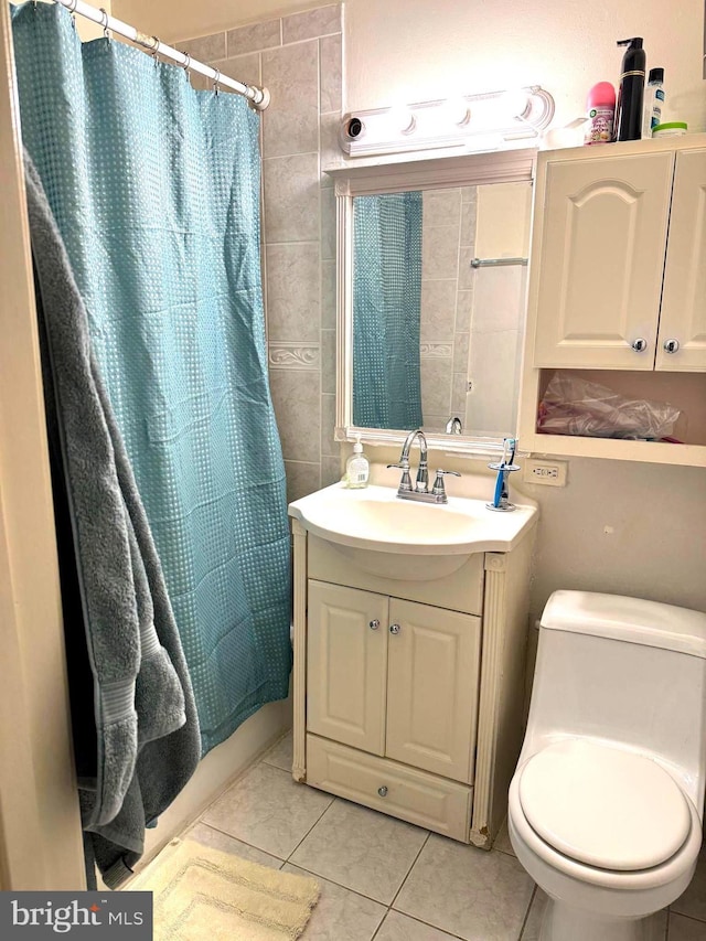 7332 Lee Hwy Unit 201, Falls Church, VA 22046 - bathroom featuring tile patterned flooring, toilet, vanity, shower / bathtub combination with curtain, and tile walls