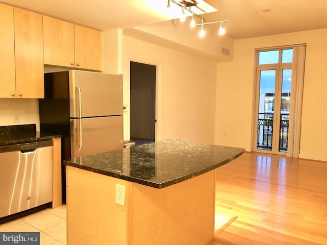 155 Potomac Psge Unit 634, Oxon Hill, MD 20745 - kitchen featuring appliances with stainless steel finishes, dark stone counters, a center island, light wood-style floors, and track lighting