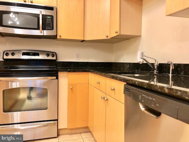 155 Potomac Psge Unit 634, Oxon Hill, MD 20745 - kitchen with appliances with stainless steel finishes, dark stone counters, a sink, and light tile patterned floors