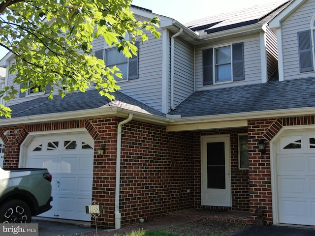 138 Pepperton Ct, Lititz, PA 17543 - view of home's exterior featuring brick siding, a garage, and roof mounted solar panels