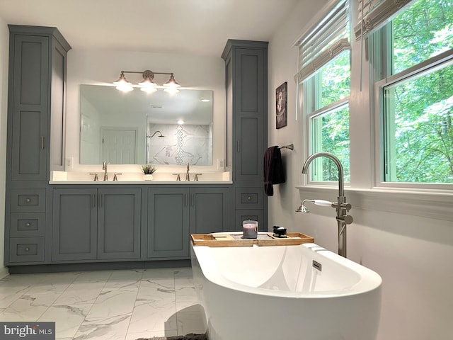 347 Lakewood Cir, Mineral, VA 23117 - bathroom with healthy amount of natural light, a freestanding bath, double vanity, and marble look tile flooring