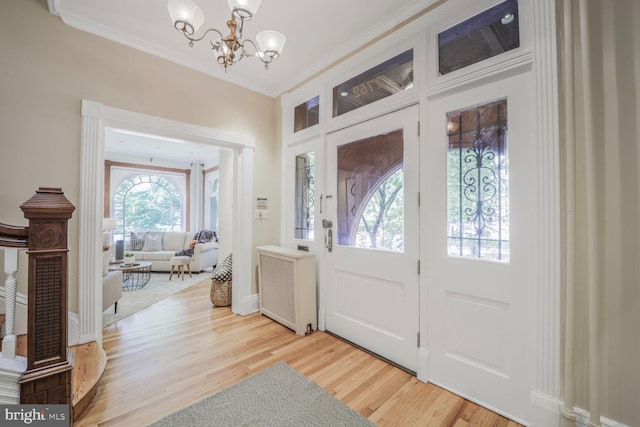 1752 17th St NW, Washington, DC 20009 - entrance foyer with radiator heating unit, a chandelier, light wood-style flooring, and crown molding