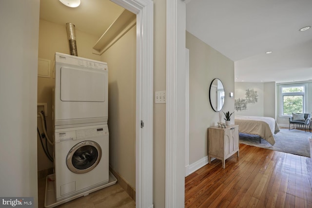 1752 17th St NW, Washington, DC 20009 - washroom with stacked washer and clothes dryer, baseboards, and hardwood / wood-style flooring