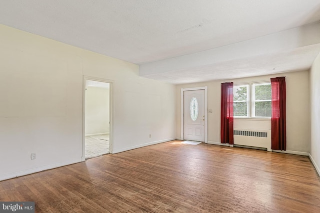218 N Hammonds Ferry Rd, Linthicum Heights, MD 21090 - unfurnished living room with radiator heating unit, wood finished floors, and baseboards