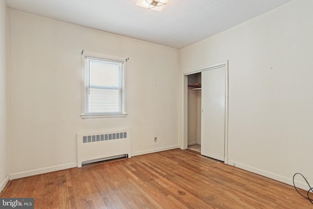 218 N Hammonds Ferry Rd, Linthicum Heights, MD 21090 - unfurnished bedroom featuring radiator heating unit, wood finished floors, baseboards, and a closet