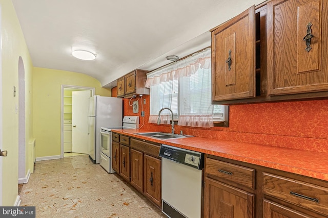 218 N Hammonds Ferry Rd, Linthicum Heights, MD 21090 - kitchen featuring white appliances, a sink, decorative backsplash, brown cabinetry, and vaulted ceiling