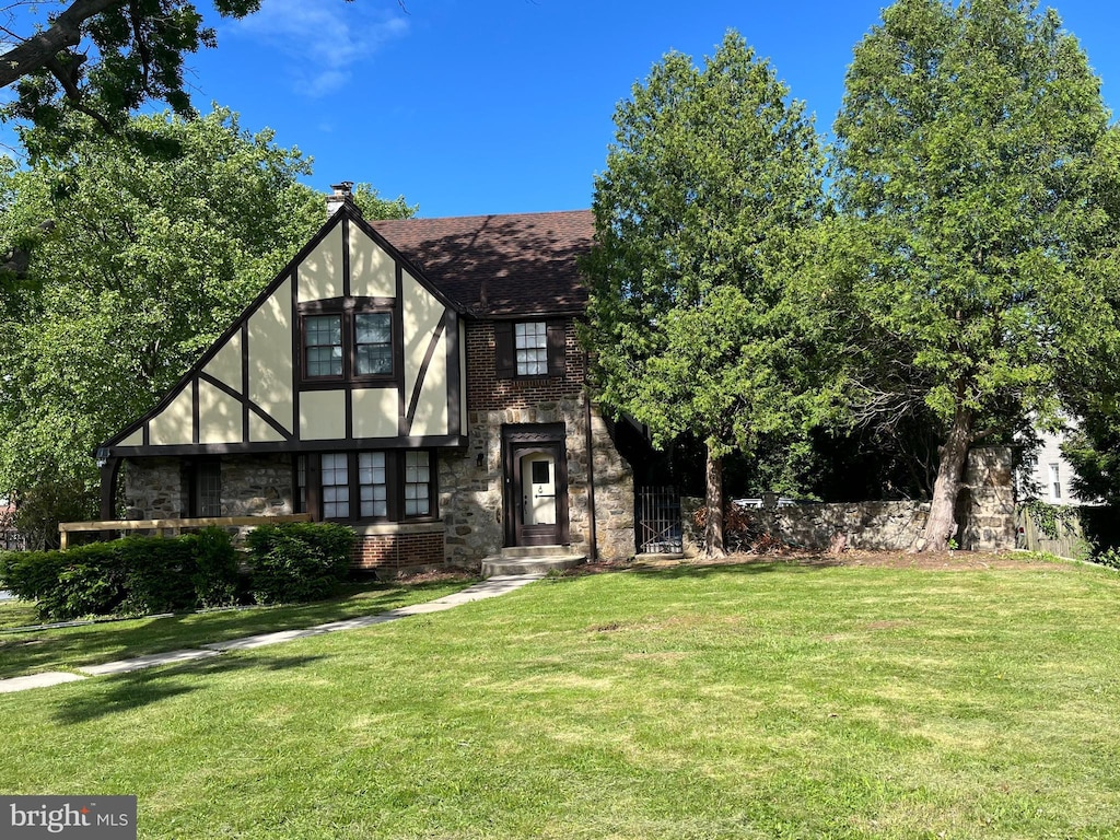105 Hollywood Ave, Reading, PA 19606 - tudor house featuring a front lawn, brick siding, roof with shingles, and stone siding