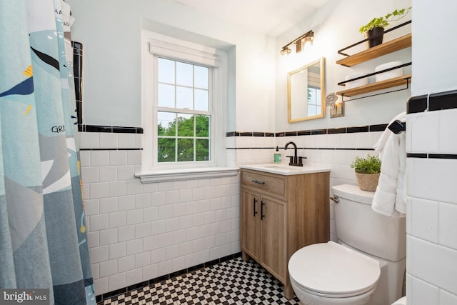 511 Wilton Rd, Towson, MD 21286 - bathroom with tile walls, a wainscoted wall, vanity, toilet, and curtained shower
