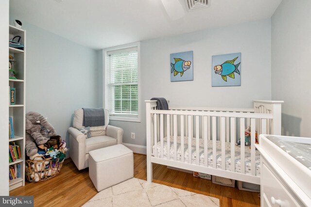 511 Wilton Rd, Towson, MD 21286 - bedroom featuring wood finished floors and a crib