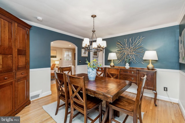 511 Wilton Rd, Towson, MD 21286 - dining area with arched walkways, light wood-style flooring, a chandelier, and crown molding