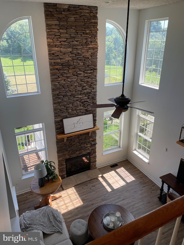 2974 Corona Ct, Manchester, MD 21102 - living room featuring baseboards, a stone fireplace, a high ceiling, wood finished floors, and ceiling fan