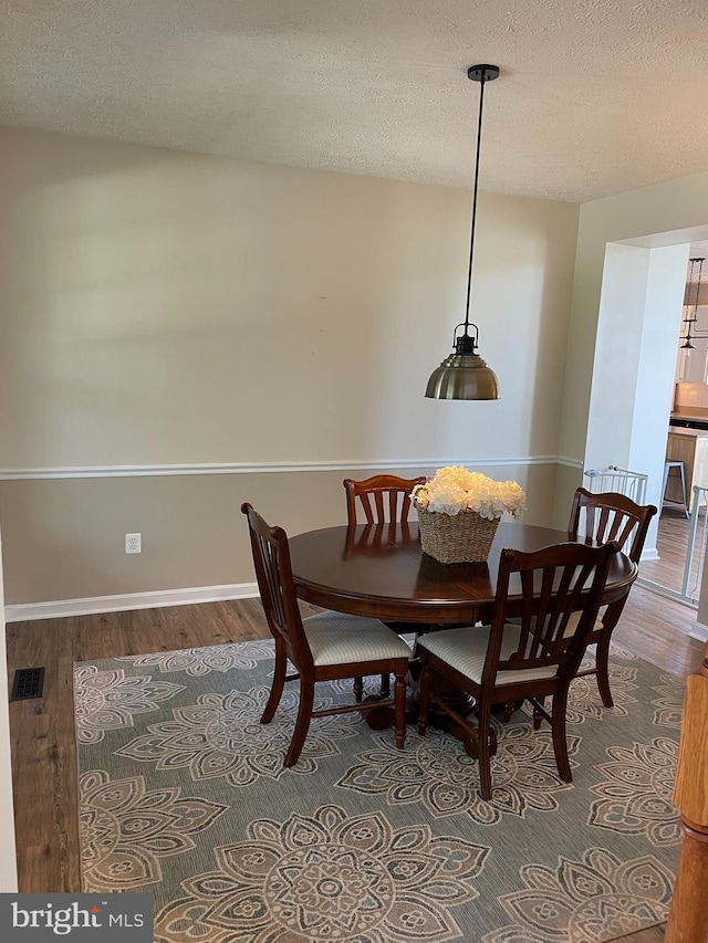 2974 Corona Ct, Manchester, MD 21102 - dining area featuring wood finished floors, a textured ceiling, and baseboards