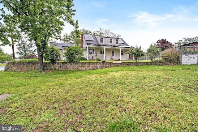 1010 Hampton Dr, Eastampton, NJ 08060 - back of property featuring roof mounted solar panels, a porch, a yard, and a chimney