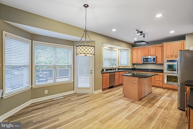 46825 Northbrook Way, Sterling, VA 20164 - kitchen with stainless steel appliances, a kitchen island, a sink, light wood-style flooring, and dark countertops