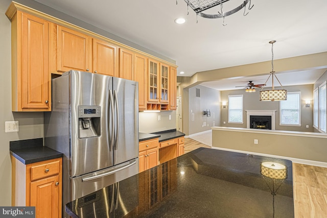 46825 Northbrook Way, Sterling, VA 20164 - kitchen with stainless steel refrigerator with ice dispenser, ceiling fan, light wood finished floors, a warm lit fireplace, and glass insert cabinets