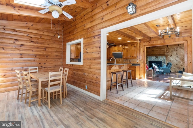 26 Wallamsey Ln, Chesapeake City, MD 21915 - dining room featuring wooden ceiling with exposed beams, ceiling fan, wood walls, a chandelier, and light wood-type flooring