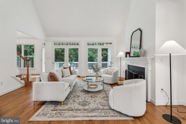 8109 Crooked Oaks Ct, Gainesville, VA 20155 - living room with plenty of natural light, wood finished floors, high vaulted ceiling, a fireplace, and stairs