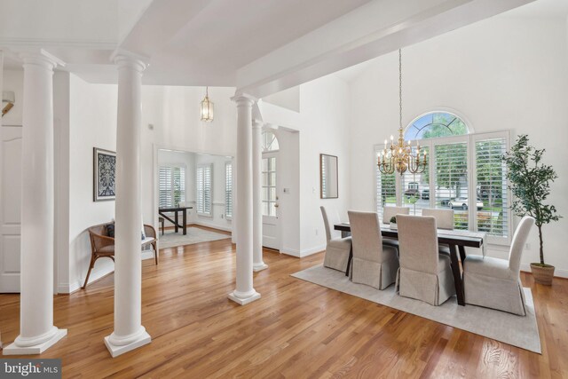 8109 Crooked Oaks Ct, Gainesville, VA 20155 - dining area with light wood-style flooring, a high ceiling, baseboards, and a chandelier