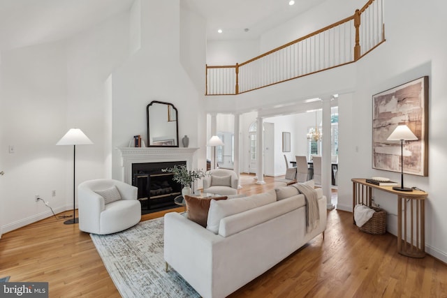 8109 Crooked Oaks Ct, Gainesville, VA 20155 - living room featuring decorative columns, high vaulted ceiling, light wood-style floors, baseboards, and recessed lighting