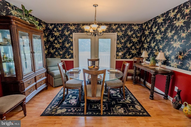 27836 Clearwater Ct, Salisbury, MD 21801 - dining area featuring wallpapered walls, a wainscoted wall, a chandelier, wood finished floors, and french doors