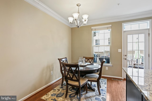 4631 Hudson St, Baltimore, MD 21224 - dining area featuring ornamental molding, a chandelier, wood finished floors, and baseboards