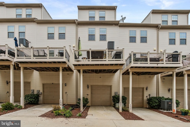 4631 Hudson St, Baltimore, MD 21224 - rear view of property featuring an attached garage, cooling unit, driveway, and a wooden deck