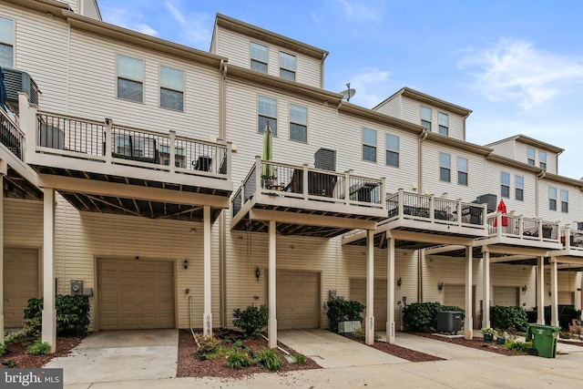 4631 Hudson St, Baltimore, MD 21224 - back of house featuring a garage, driveway, central AC unit, and a wooden deck