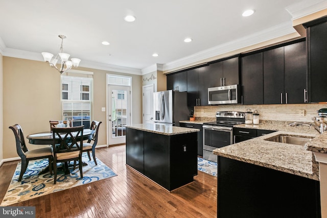 4631 Hudson St, Baltimore, MD 21224 - kitchen with appliances with stainless steel finishes, dark cabinets, a sink, a kitchen island, and a chandelier