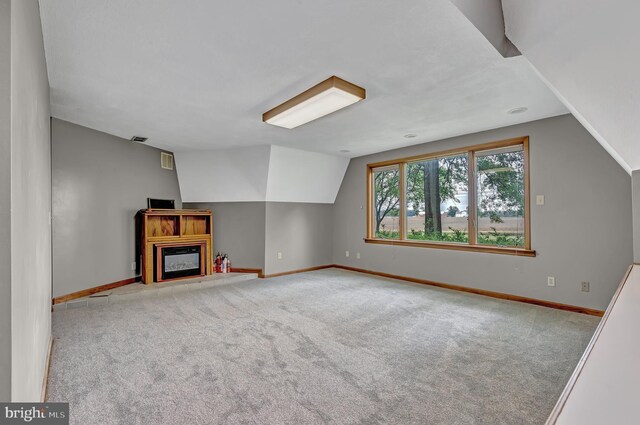 865 Windsor Perrineville Rd, East Windsor, NJ 08520 - unfurnished living room with lofted ceiling, baseboards, carpet flooring, and a glass covered fireplace