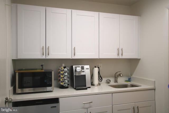 1325 18th St NW Unit Rp-105, Washington, DC 20036 - kitchen with stainless steel microwave, white cabinetry, and refrigerator