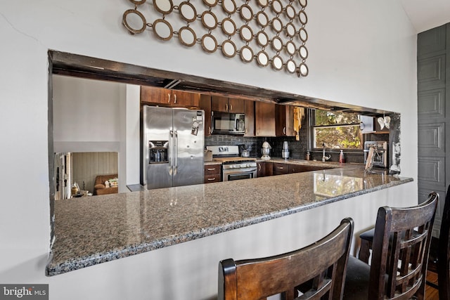 2300 Andover Rd, Cinnaminson, NJ 08077 - kitchen featuring appliances with stainless steel finishes, a peninsula, stone countertops, and decorative backsplash