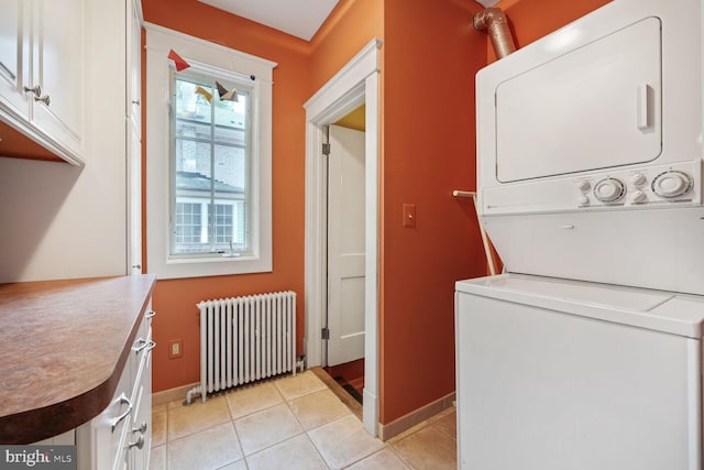 103 E Monroe Ave, Alexandria, VA 22301 - washroom featuring radiator, estacked washer and dryer, cabinet space, and light tile patterned floors