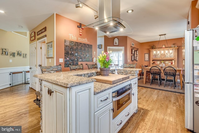 8 Adams Ln, Hainesport, NJ 08036 - kitchen with appliances with stainless steel finishes, light wood-style flooring, a kitchen island, white cabinetry, and wainscoting