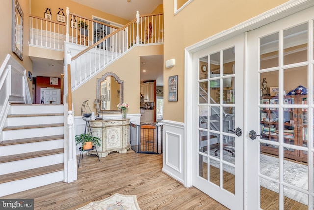 8 Adams Ln, Hainesport, NJ 08036 - entryway with light wood-type flooring, wainscoting, stairs, a decorative wall, and french doors